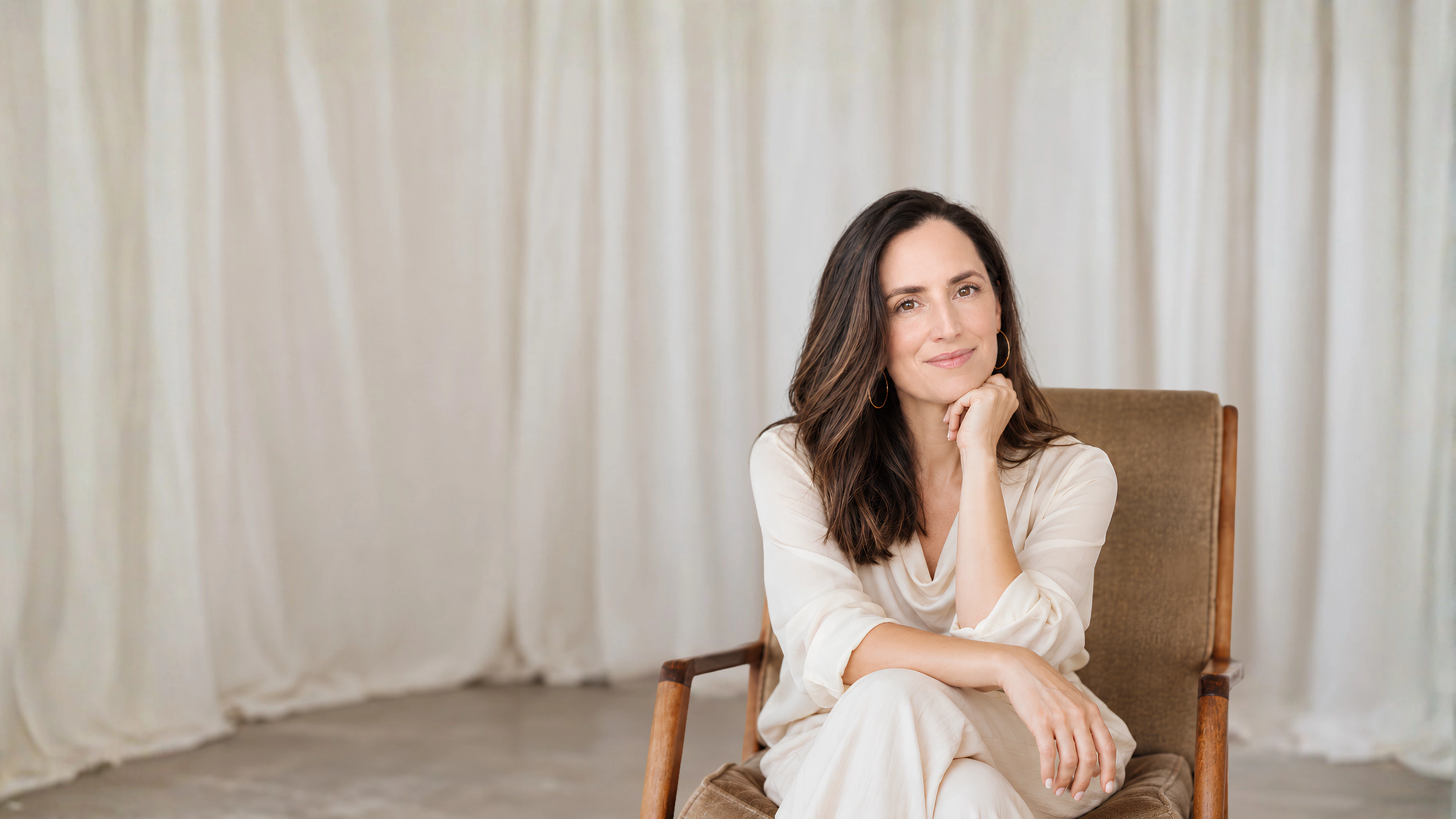 Fiona seated in a warm neutral studio portrait